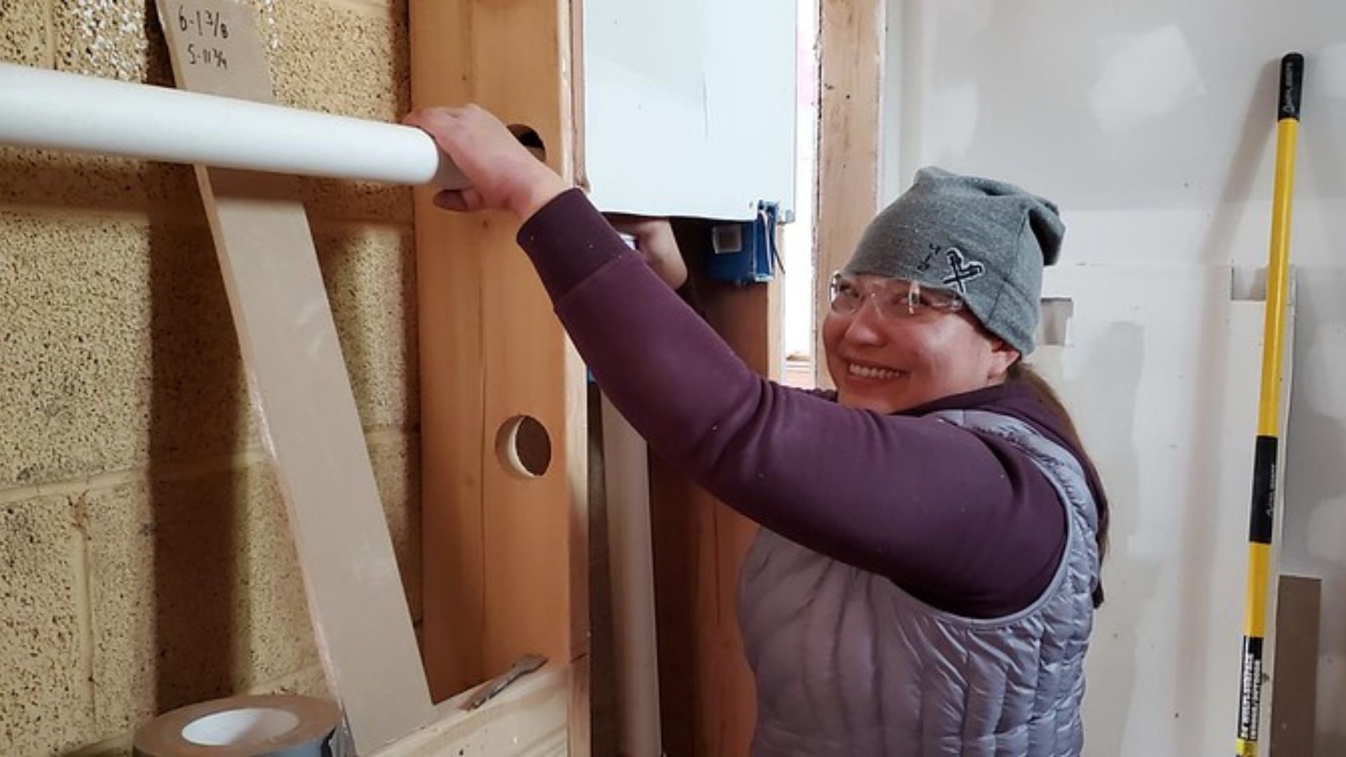 Female IWSH Plumber installing pipe
