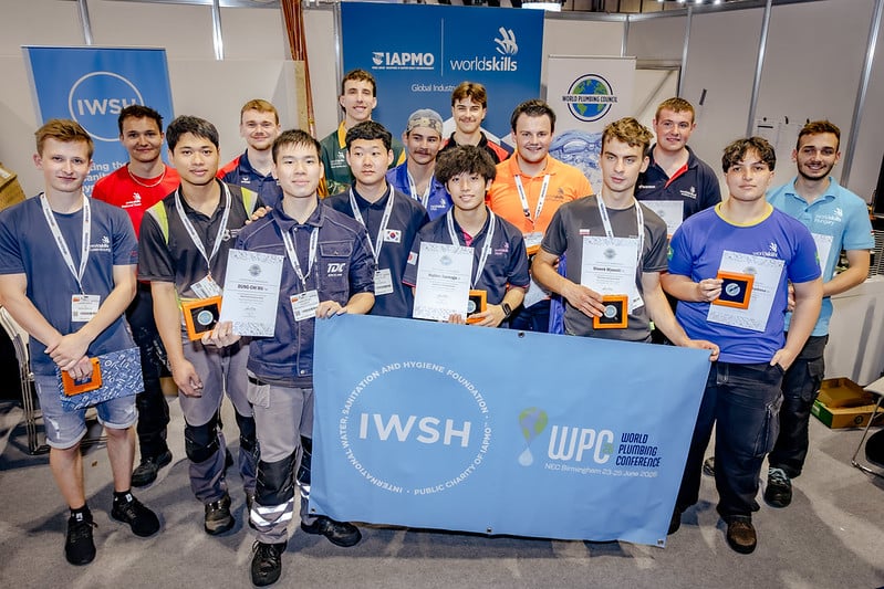 16 plumbers pose with awards at the WPC2026