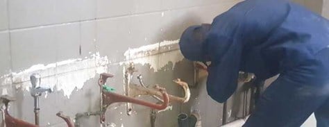Plumbing apprentice works at homeless shelter in Johannesburg, South Africa