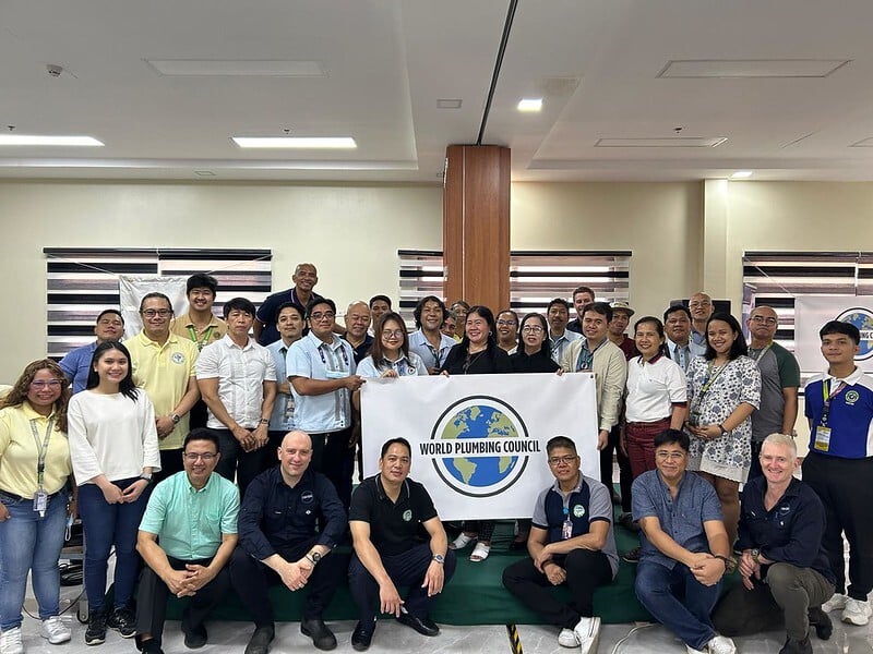 Group picture of people holding World Plumbing Council poster
